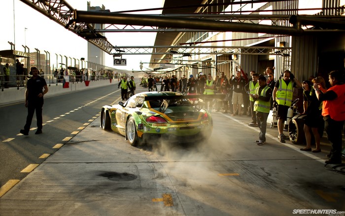 BMW race car in pit lane with crowd