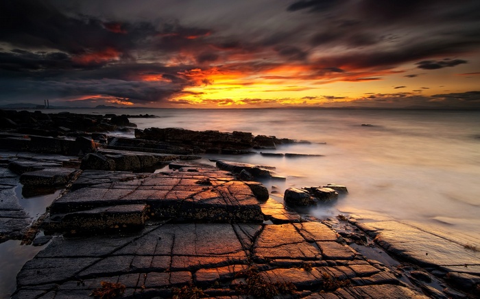 Rocky coastline at sunset with dramatic clouds