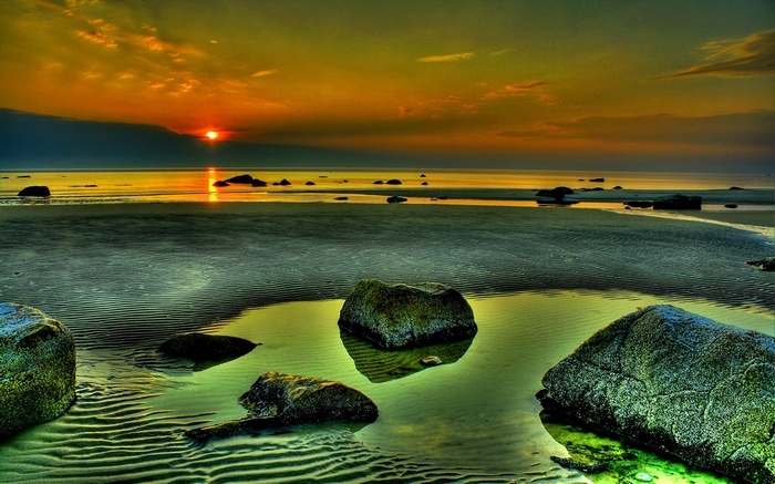 Sunset over a rocky beach with tide pools