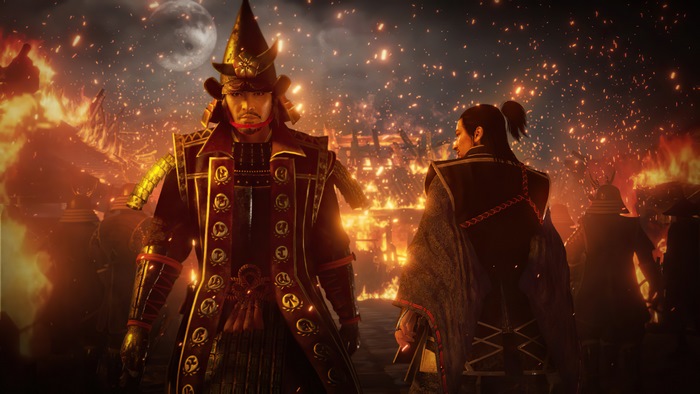 Two samurai warriors stand before a burning village in Nioh 2