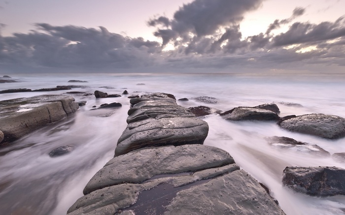 Rocky coastline with waves at sunset