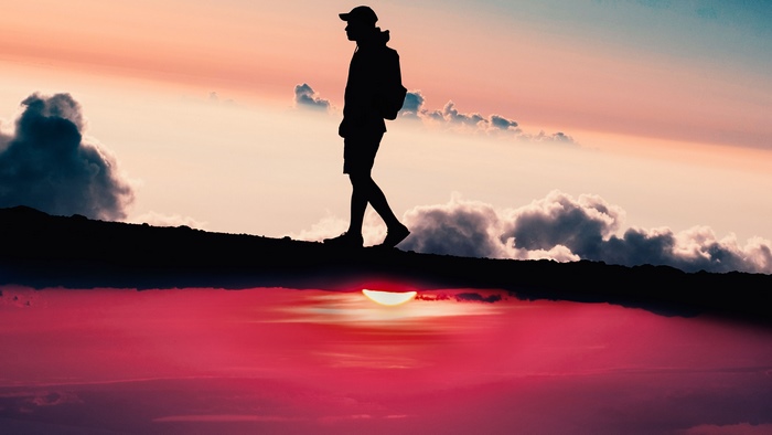 Silhouette of a person walking at sunset