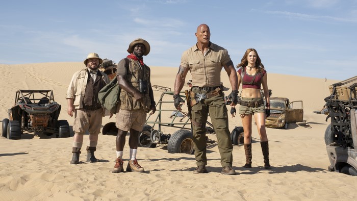 Four adventurers in a desert with vehicles