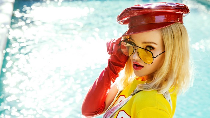 Dove Cameron in red hat and yellow shirt