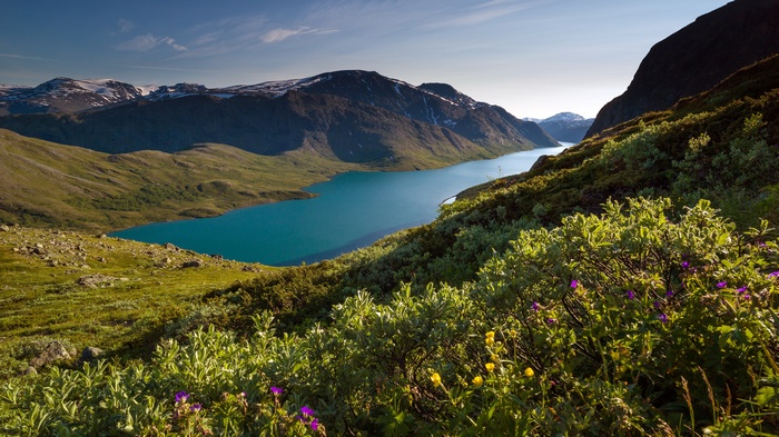Turquoise lake surrounded by mountains and green hills