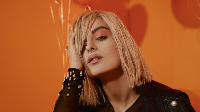 Bebe Rexha with blonde hair and orange eyeshadow