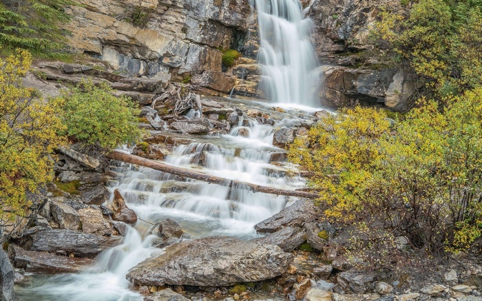 Waterfall cascading over rocks with autumn foliage