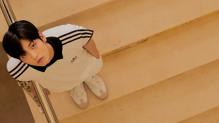 A young man in an Adidas tracksuit on stairs