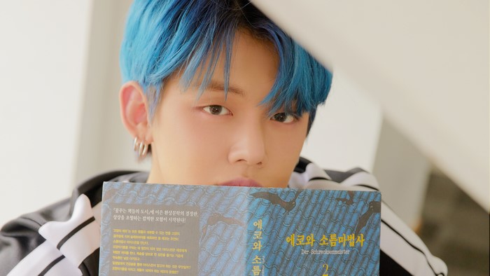 Yeonjun from TXT holding a book