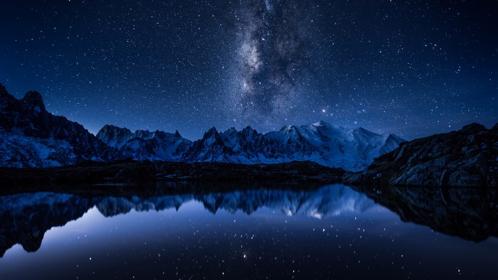Milky Way over snow-capped mountains reflected in a lake