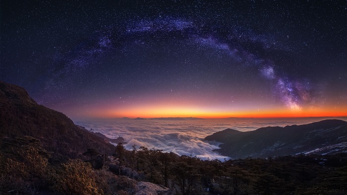 Mountain landscape with Milky Way and clouds at night 4K