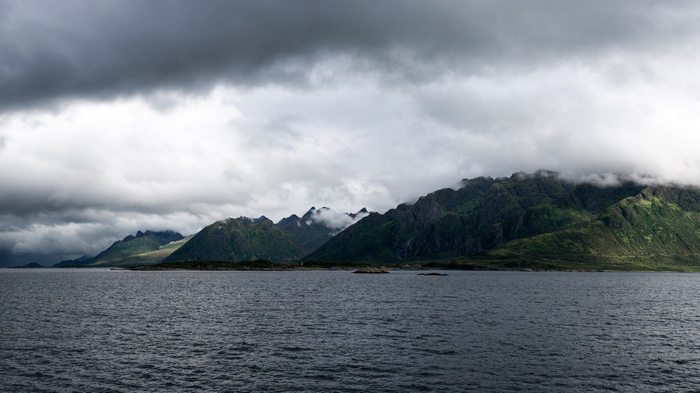 Dark clouds over a Norwegian fjord with mountains