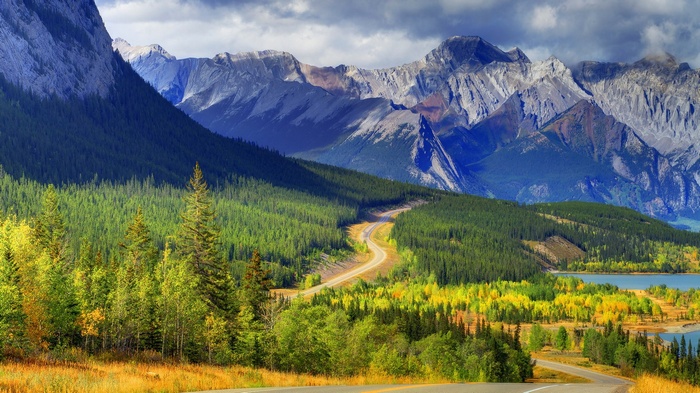 Winding road through a mountain landscape with autumn trees