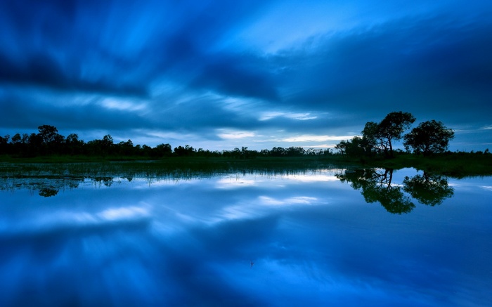 Blue sky reflected in a calm lake at dusk