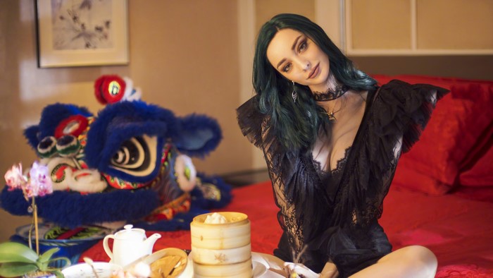 Woman in black lace outfit with dim sum and lion head