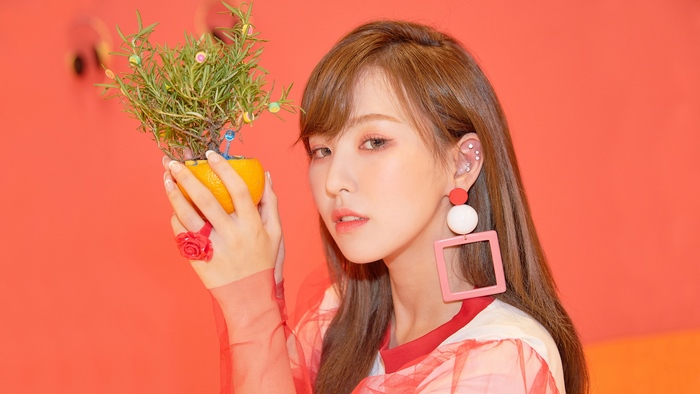 Wendy from Red Velvet holding a potted plant