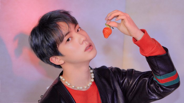 Jin from BTS holding a strawberry