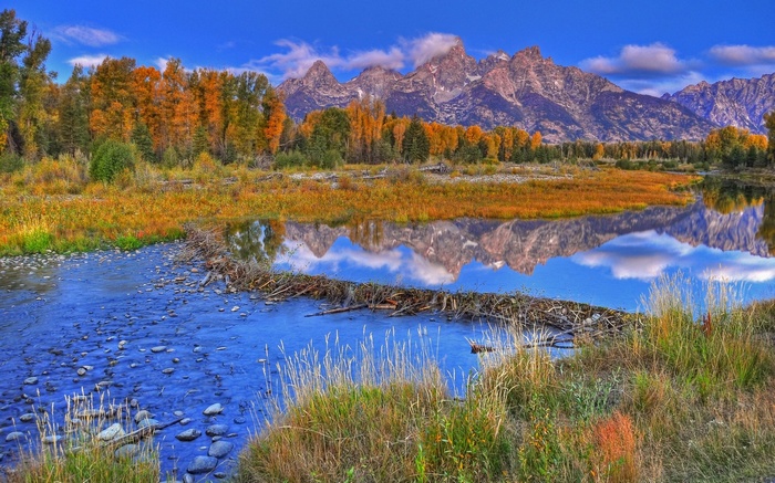 Autumn landscape with mountains and river reflection
