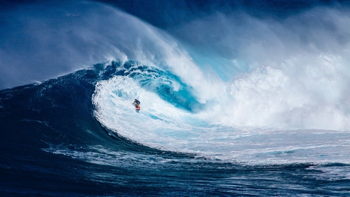 Surfer riding a giant wave in the ocean 4K