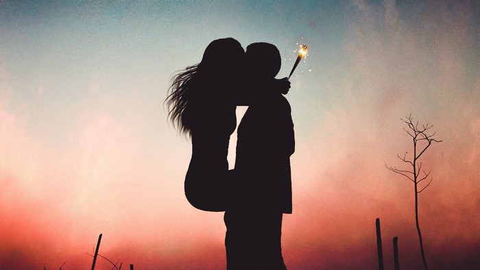 Couple kissing with sparkler at sunset 4K