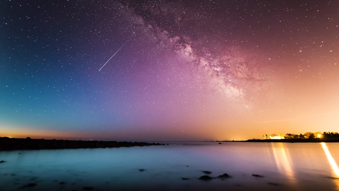 Milky Way galaxy over a calm ocean at dusk