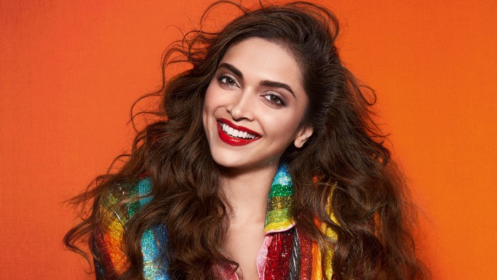 Deepika Padukone smiling in a colorful sequined jacket
