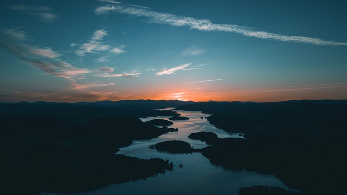 Sunrise over a winding river and mountains