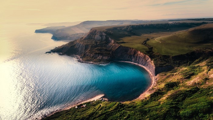 Aerial view of a horseshoe bay with cliffs and sea