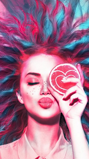 Girl with pink and blue hair holding grapefruit slice