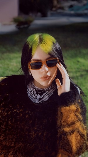 Billie Eilish wearing sunglasses and necklaces