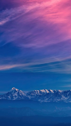 Snow-capped mountains under a colorful sky