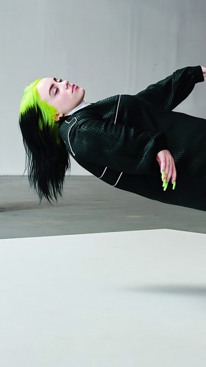 Billie Eilish in black outfit with green hair
