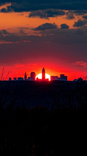 City skyline silhouetted against a vibrant sunset