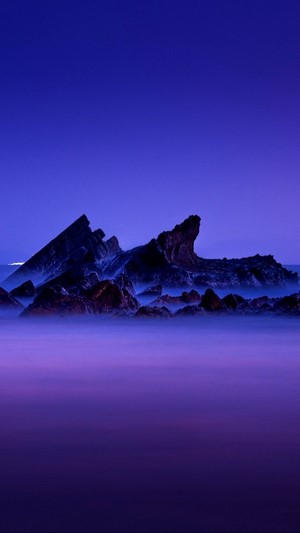 Rocky shore at night with purple mist