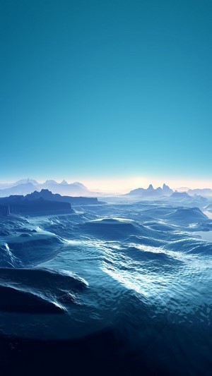 Blue ocean waves and distant mountains under a clear sky
