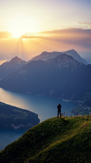 Man photographing mountains at sunrise 4K
