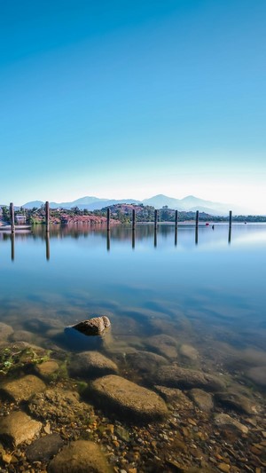 Lake with wooden posts and mountains
