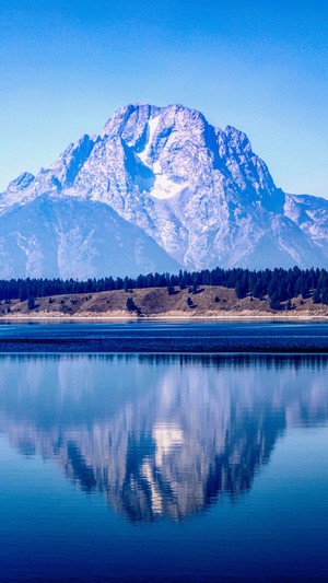 Snow-capped mountain reflected in a calm lake