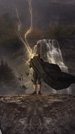 Black Adam with lightning near a waterfall