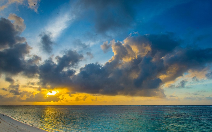 Sunset over the ocean with dramatic clouds