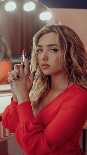 Peyton List holding lipstick like a gun