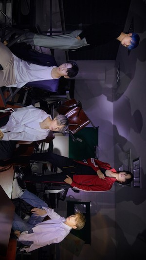 TXT members in a room with chairs