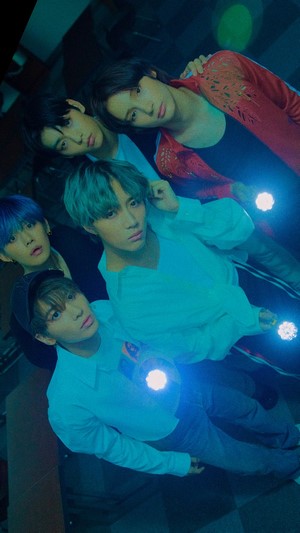 TXT members with flashlights in dark setting