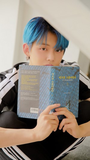 Yeonjun from TXT holding a book
