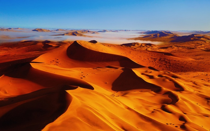 Desert sand dunes with fog and blue sky