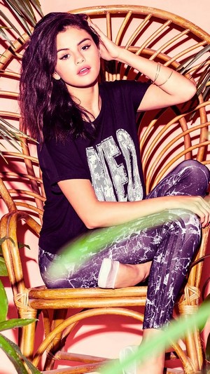 Selena Gomez in a wicker chair