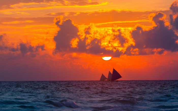 Sailboats on the ocean at sunset