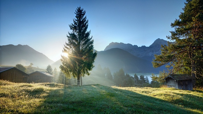 Sunrise over a mountain valley with cabins and trees