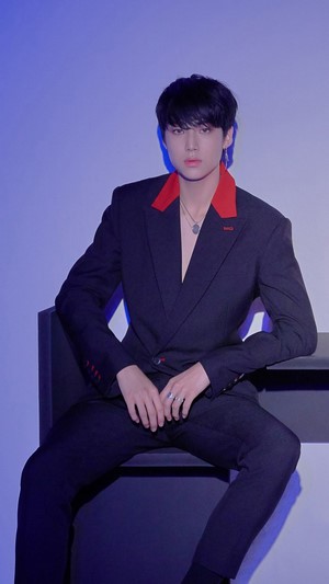 Lee Eunsang in a black suit with red accents
