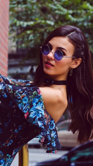 Victoria Justice wearing sunglasses and a floral dress